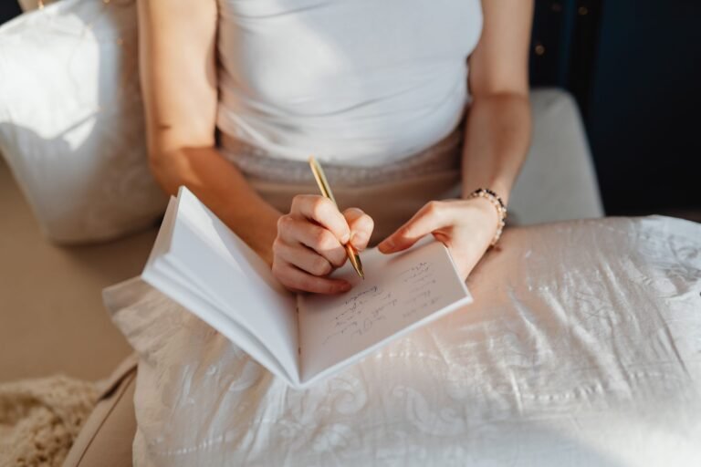 Person writing in a journal by soft morning light, practicing gratitude