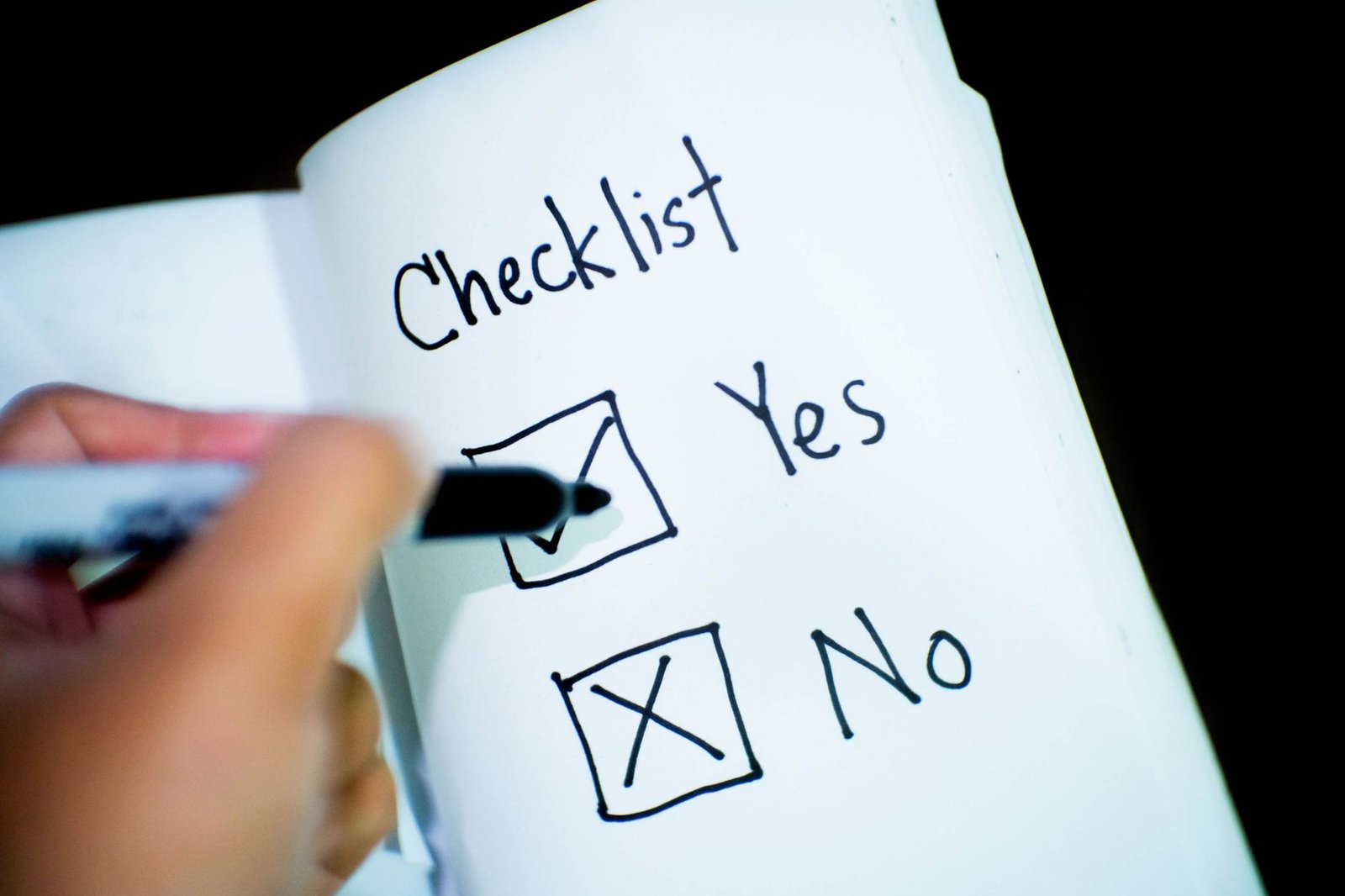 Person writing down options and next steps in a notebook to solve a problem
