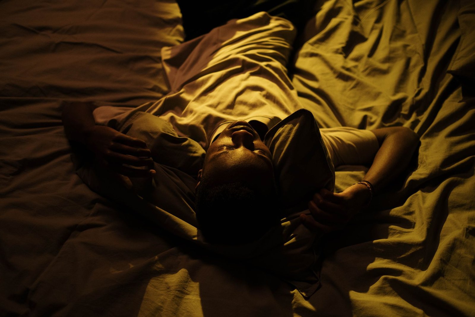 Person tossing and turning in bed during a restless night of fragmented sleep