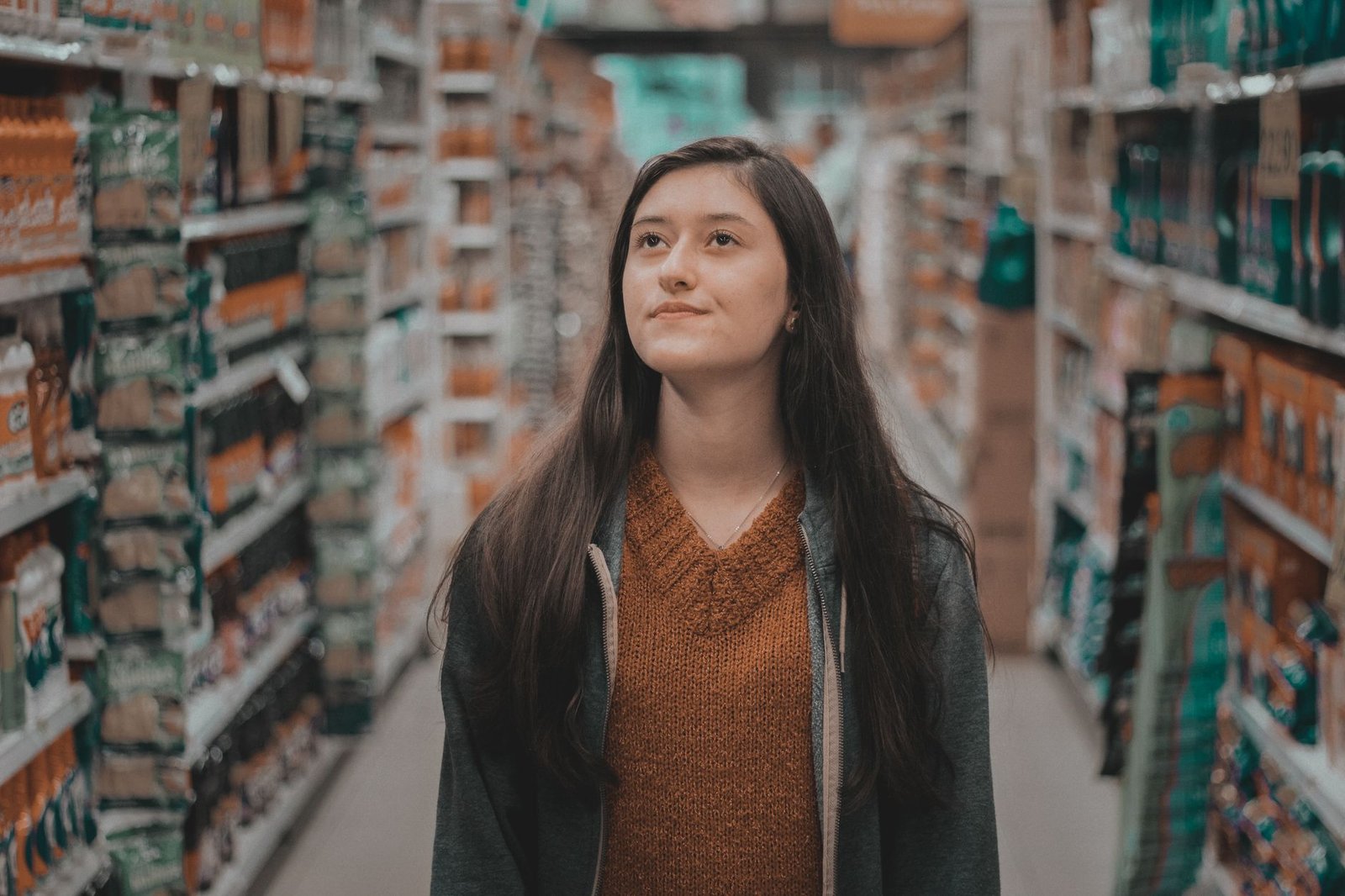 Person standing frozen in a grocery aisle, unable to decide what to choose