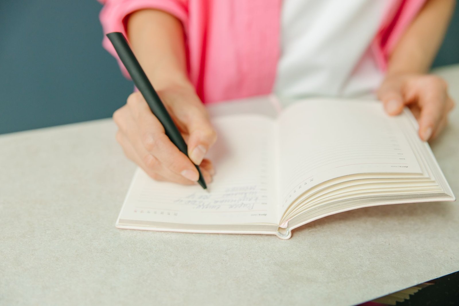 Person writing a simple morning routine in a planner to reduce daily decisions