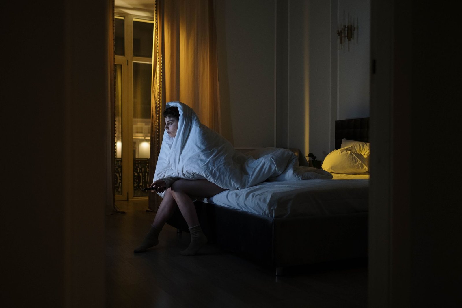 Woman lying awake in bed late at night, unable to sleep