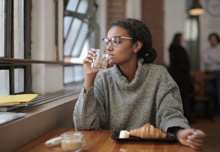 Woman drinking a glass of water, staying hydrated