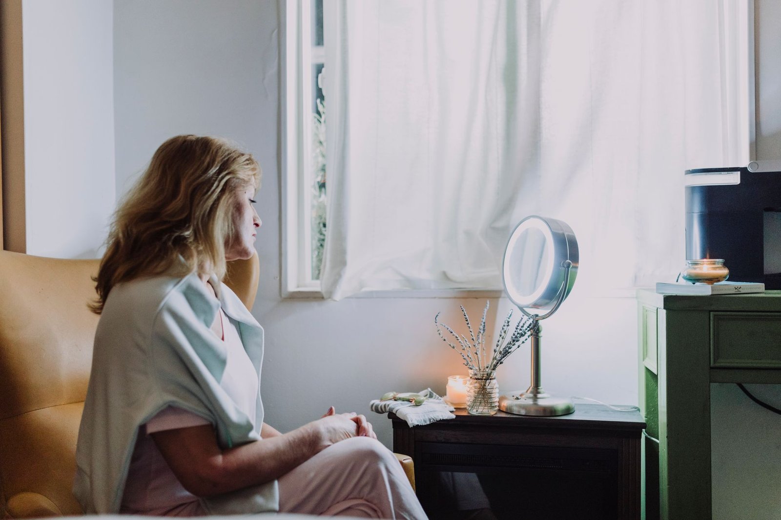 Woman sitting calmly by a window, reflecting on an ordinary but meaningful day