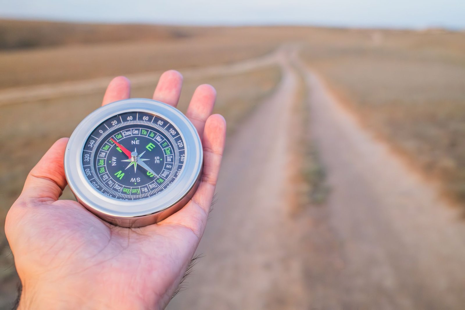 Close-up of a compass held in someone's hand outdoors, symbolizing values as a life compass