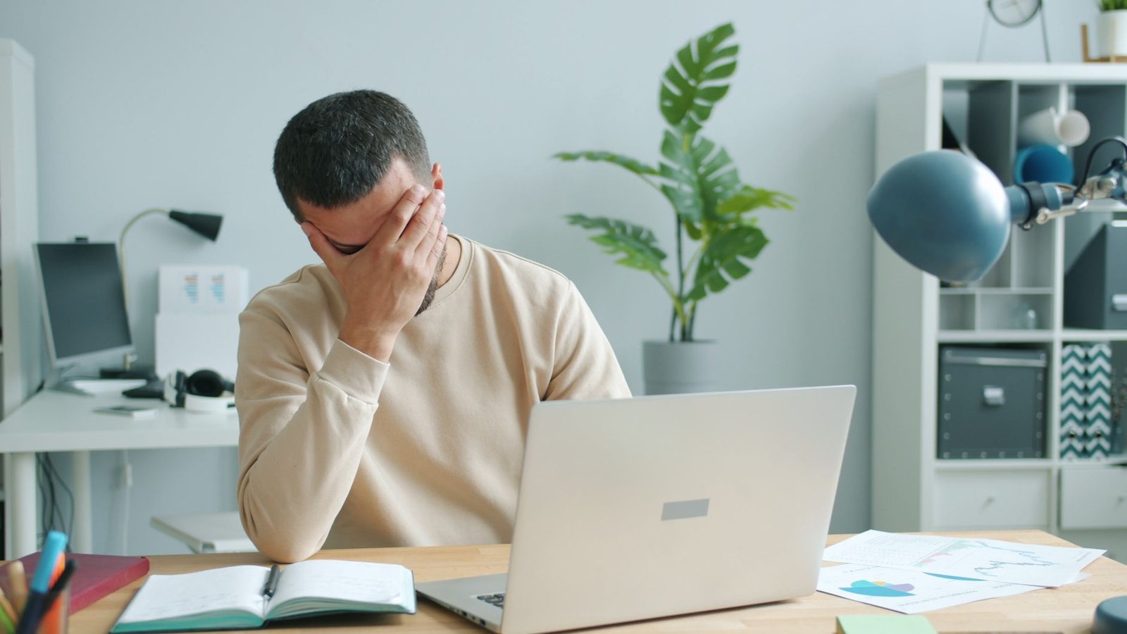 Tired person resting head on desk, showing the exhaustion of internal conflict