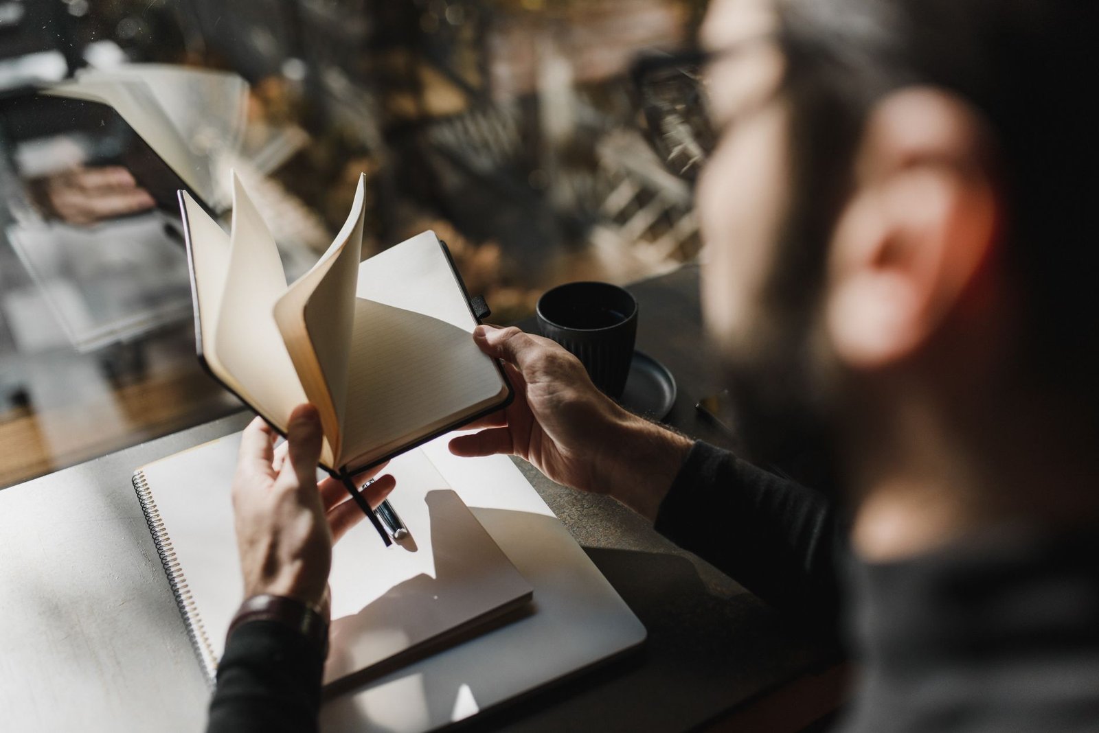 Person writing in a journal by a window, reflecting on small moments of meaning