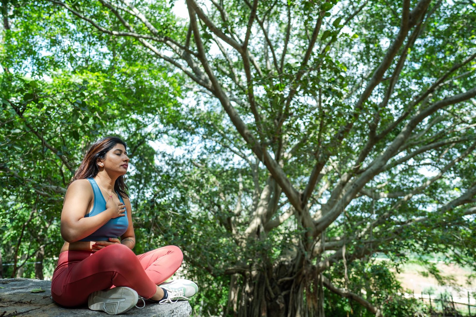 Woman sitting calmly outdoors, breathing slowly and resting